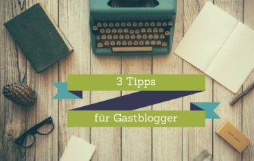 Eine Schreibmaschine, ein Buch, ein Notizheft, ein Tannenzapfen und ein Ast liegen auf einem Tisch. In der Mitte steht der Satz drei Tipps für Gastblogger.