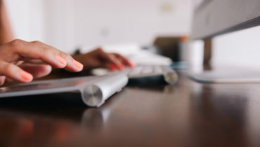 Finger auf einer zweigeteilten Tastatur, die gerade tippen.