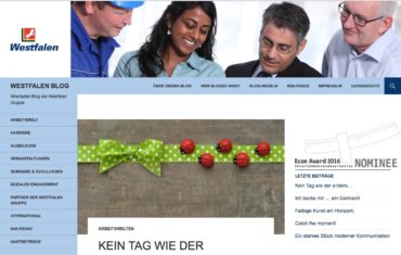 Mitarbeiter der Westfalen Ag sind im oberen Bereich des Bildes zu sehen. Eine Frau und drei Männer beugen sich leicht über etwas. Darunter ist ein Geschenkband mit einer kurzen Überschrift.