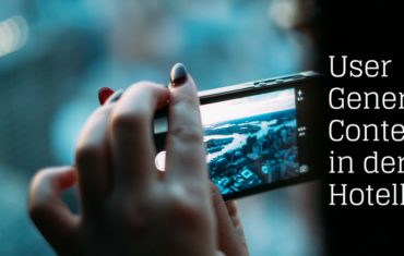 Eine Frau hält ihr Smartphone quer und fotografier die Ansicht einer Stadt