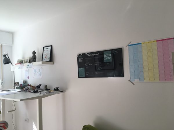 Glasnotizboard an der Wand in einem weißen Arbeitszimmer