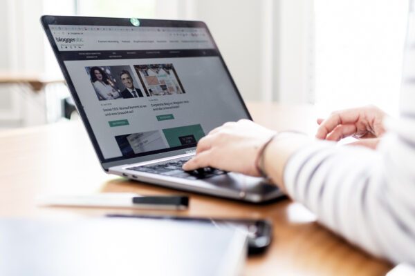Hände sind auf einer Laptoptastatur. Der Bildschirm zeigt die Startseite des Blogs bloggerabc mit verschiedenen Artikeln.